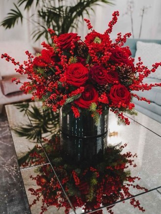 Red roses and winter berries for festive touch