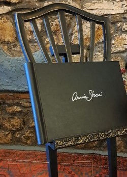 Repurpose the back of a chair as a book or frame stand at events